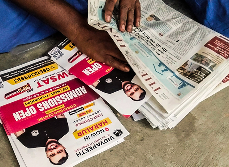 Newspaper insertion process - flyer being placed inside a daily newspaper